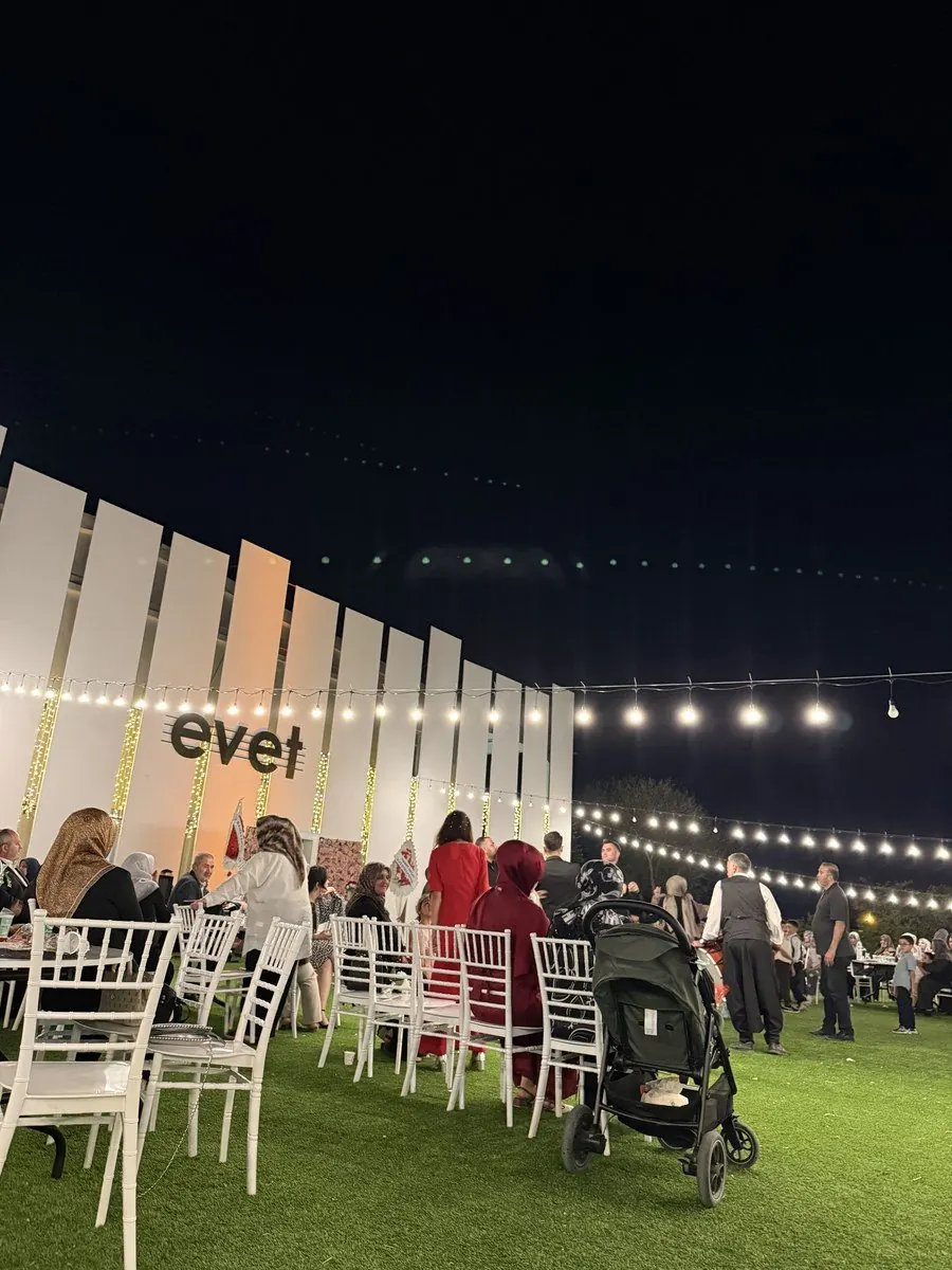Işıklı evet duvarı önünde davetliler